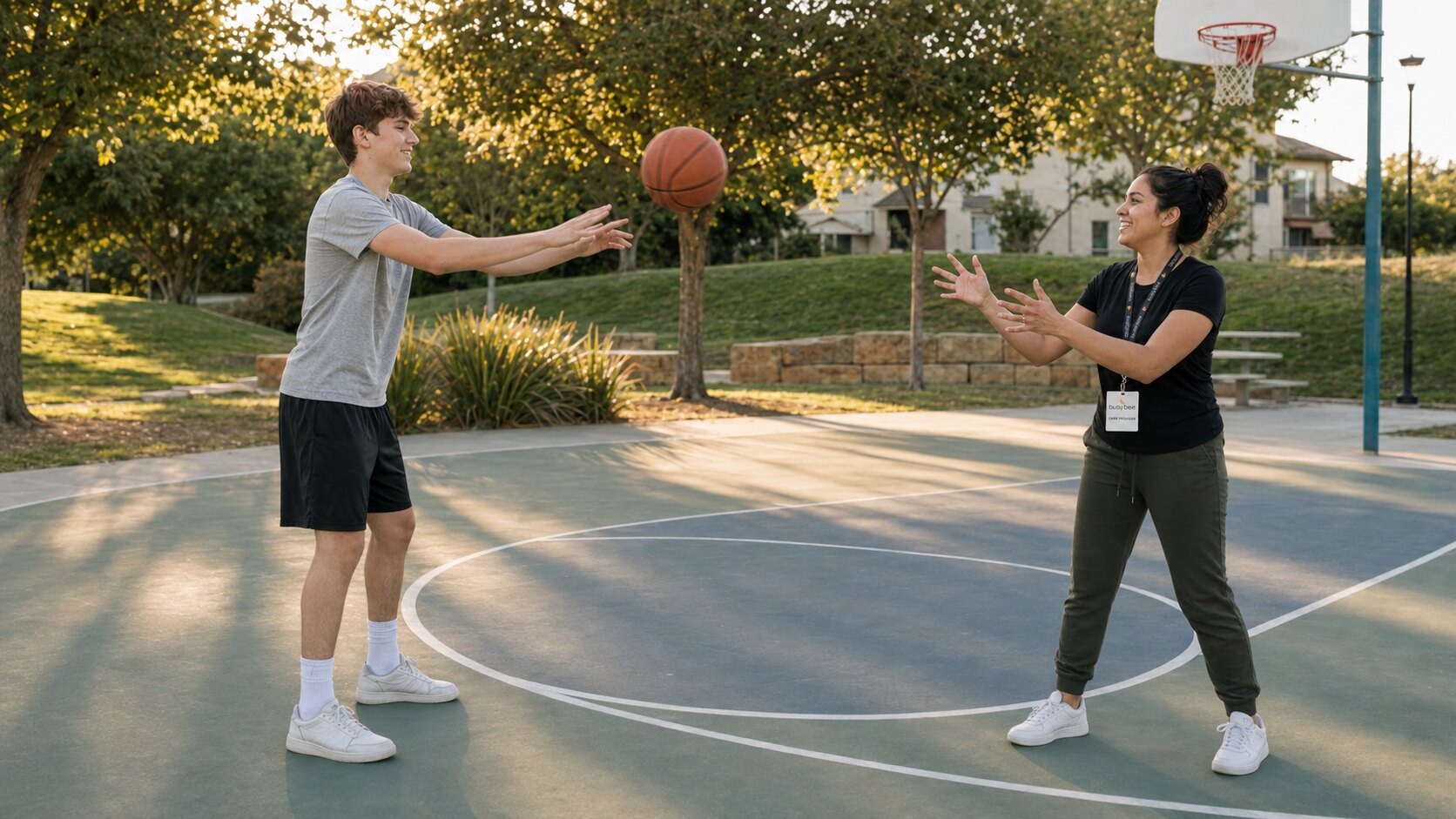 A teenager passing a basketball to a Busy Bee respite provider during a community activity.