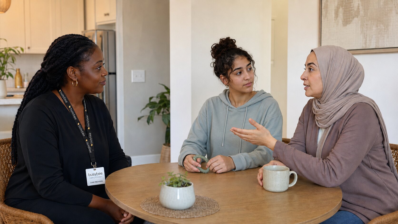 A mother speaking with a Busy Bee respite provider while her daughter listens and holds a sensory fidget.